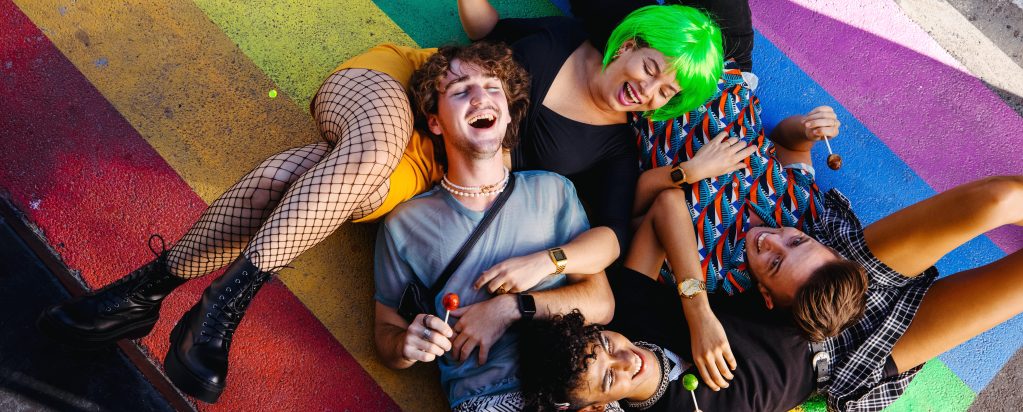Four young queer people lying down together