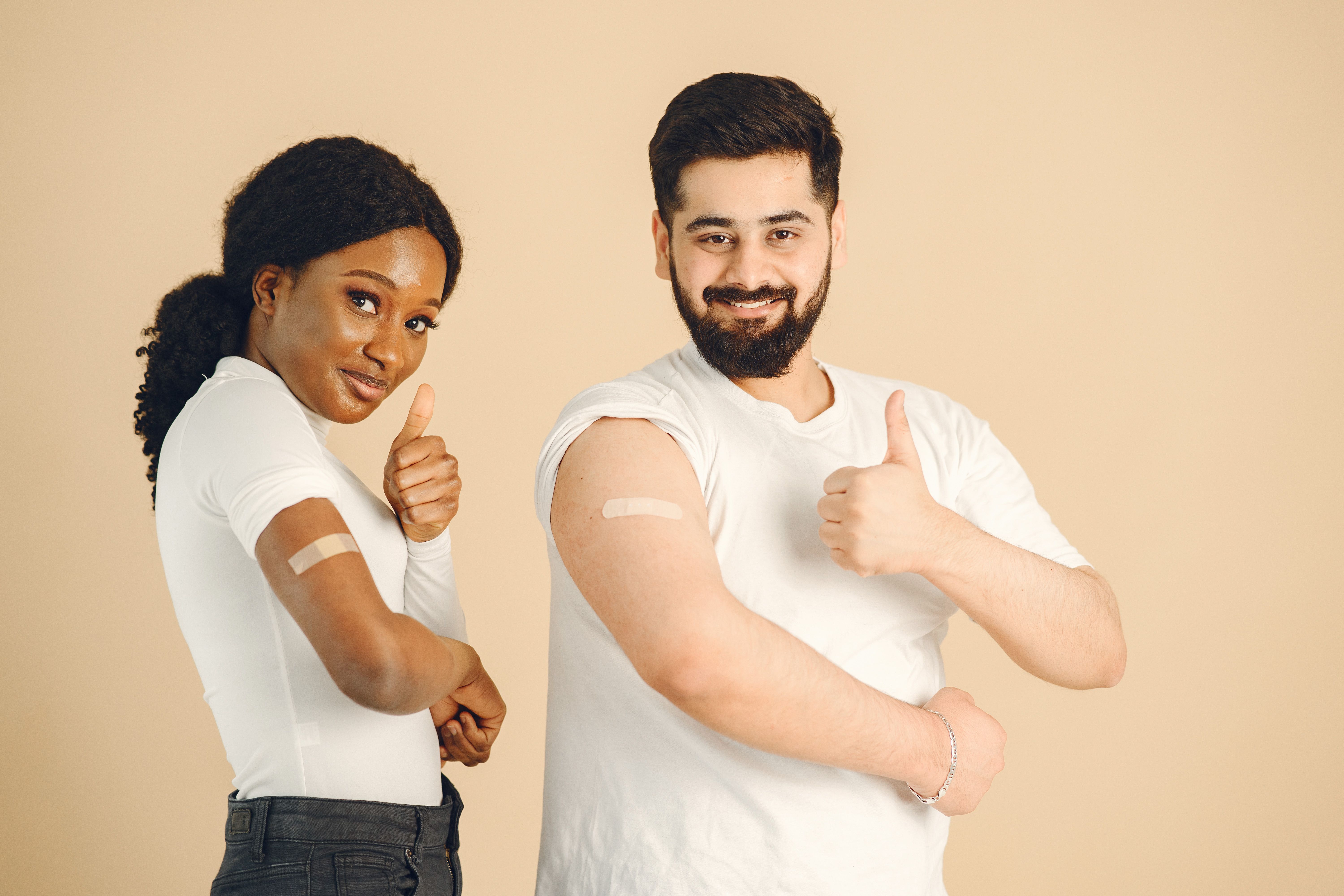 photo of people with bandaids on their arms smiling